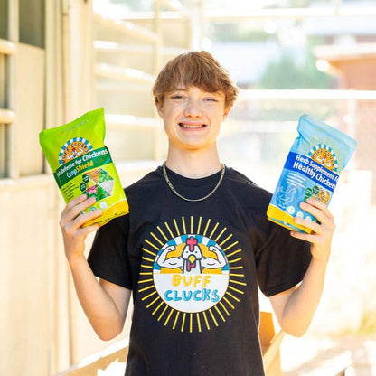 boy holding coopshield and herb supplement bundle for backyard chickens